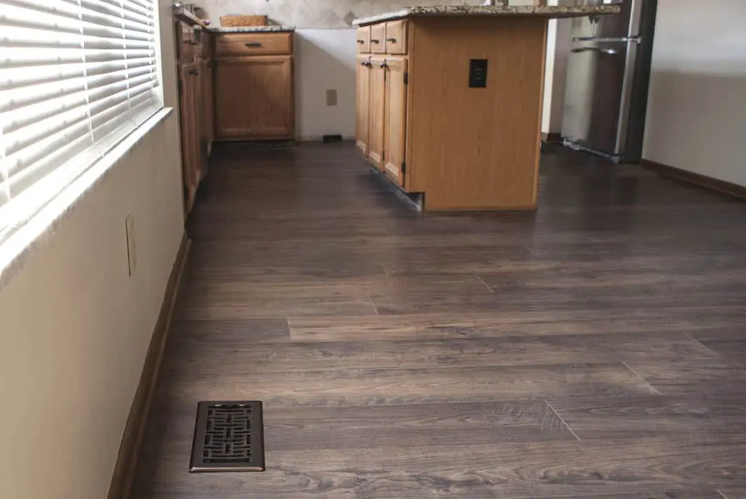 Same kitchen with dark wood-look LVT flooring after installation